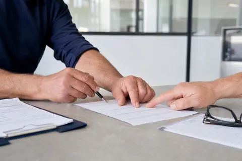 Arbeitgeber und Mitarbeitender unterzeichnen gemeinsam das Anmeldeformular