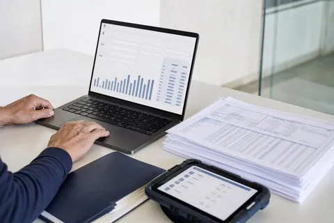 Mitarbeiter reicht die Lohnmeldung über das digitale Portal am Laptop ein